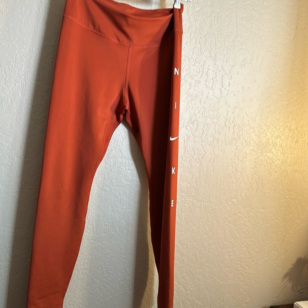 Nike leggings with side logo on the side leg size large NWOT. Burt/brick  color